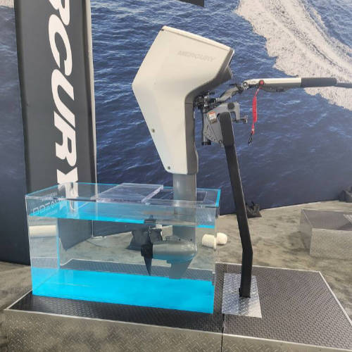 Marine outboard motor display with water tank and 'Evinrude' branding.